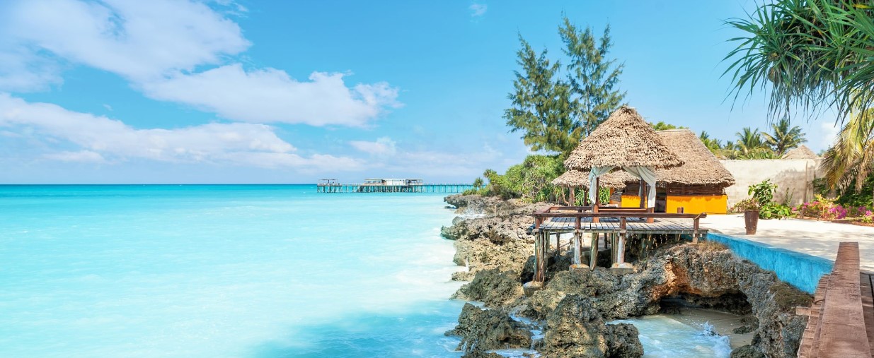 Luxury beach resort in Zanzibar, Tanzania, with turquoise waters, palm trees, and elegant oceanfront villas