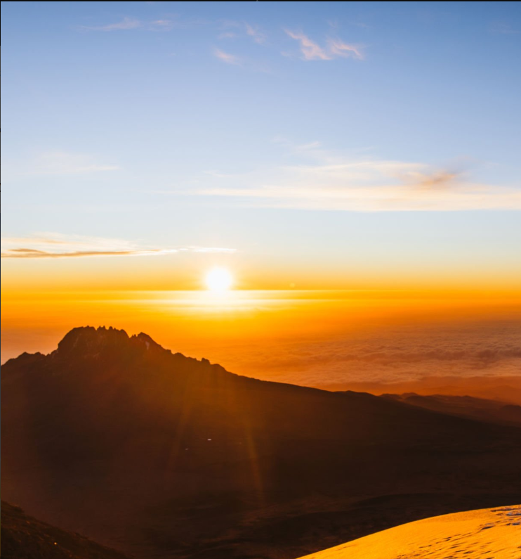 Climbers trekking Mount Kilimanjaro, Africa's highest peak, with stunning sunrise views.