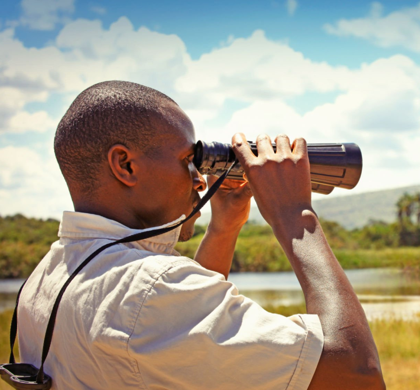 Solo traveler hiking Rwanda's Volcanoes National Park on adventure tours.