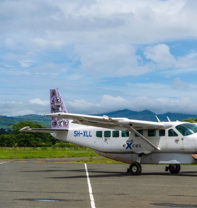 ourists arriving at Kilimanjaro International Airport with luggage under sunny skies in Tanzania
