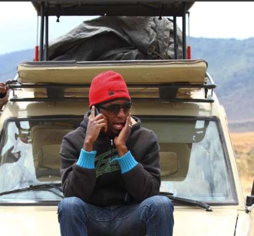 A person using a taxi app on a smartphone for ride-hailing in Tanzania.