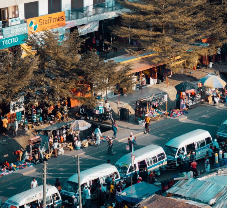 Passengers boarding a public bus in Tanzania at a busy terminal.