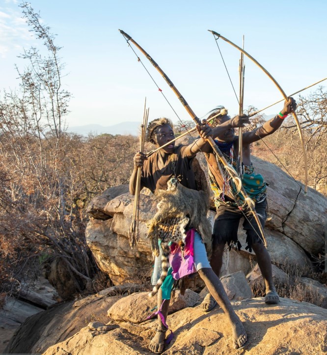 "Hadzabe tribe members in traditional attire during a cultural ceremony in Tanzania.