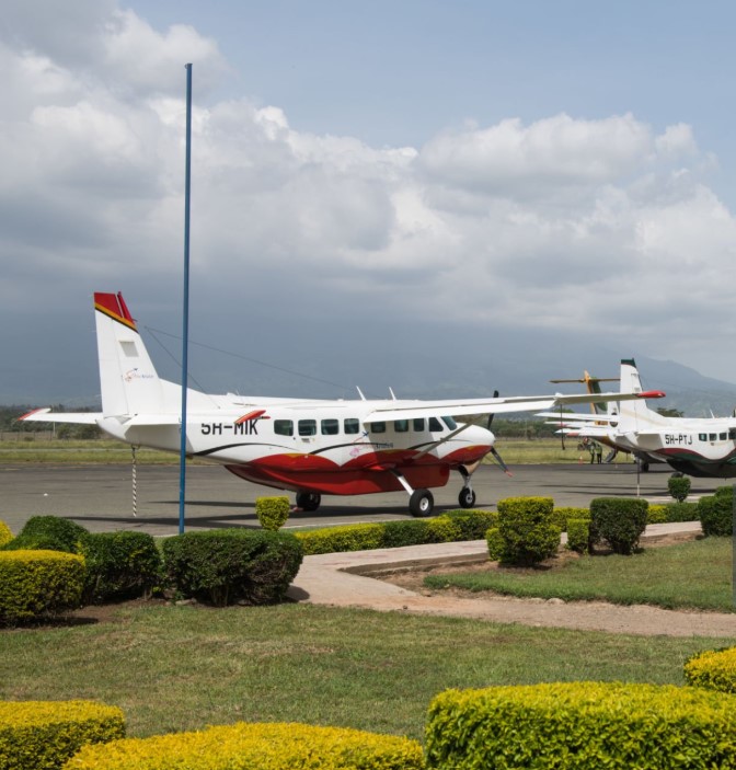 Mafia Island Airport terminal with small aircraft and tropical scenery in the background.