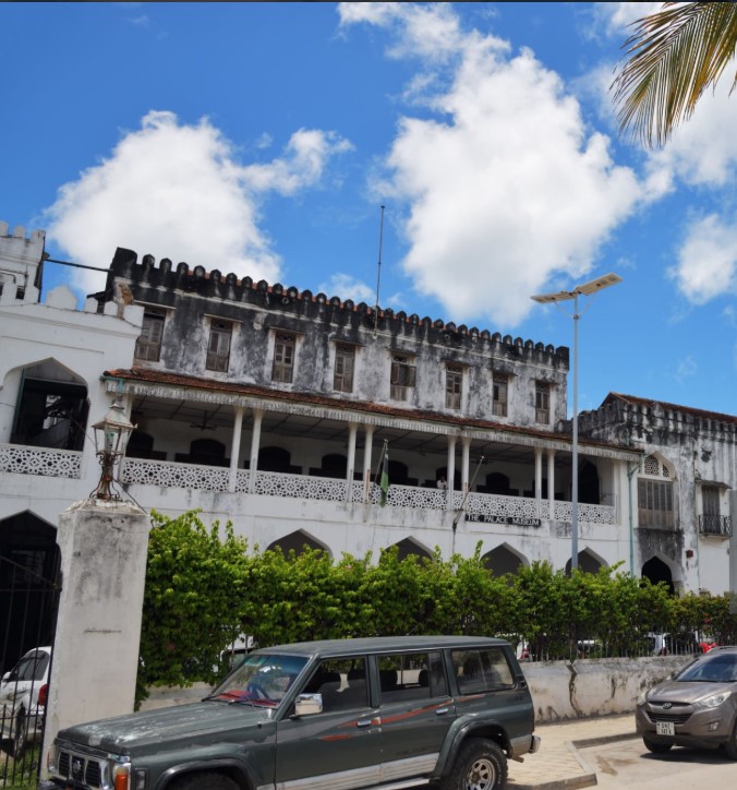 Historic streets of Stone Town, Zanzibar, with old Swahili architecture and people walking past carved wooden doors